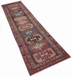 A handwoven vintage Persian runner featuring geometric medallions on a dark brown field.