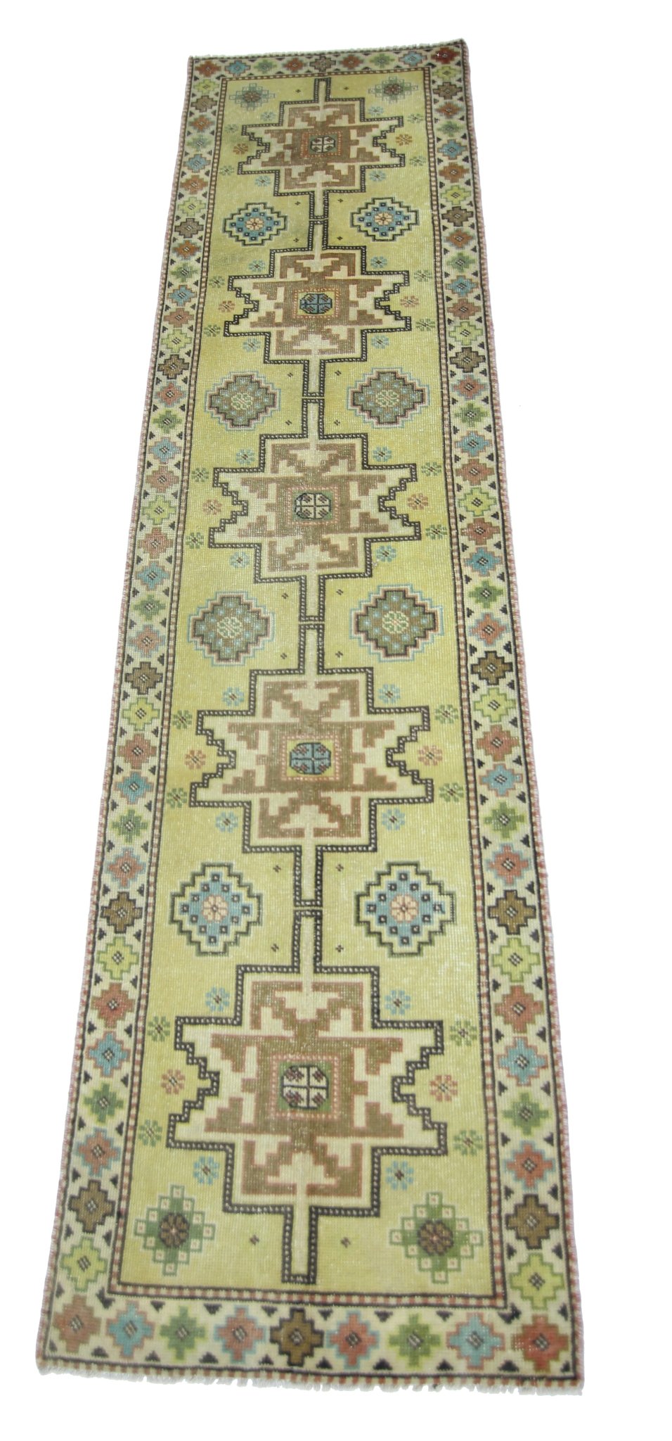 A vintage Persian runner rug featuring geometric patterns in shades of green, brown, and blue.