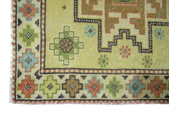 A vintage Persian runner featuring geometric patterns in green, blue, and brown on a light field.