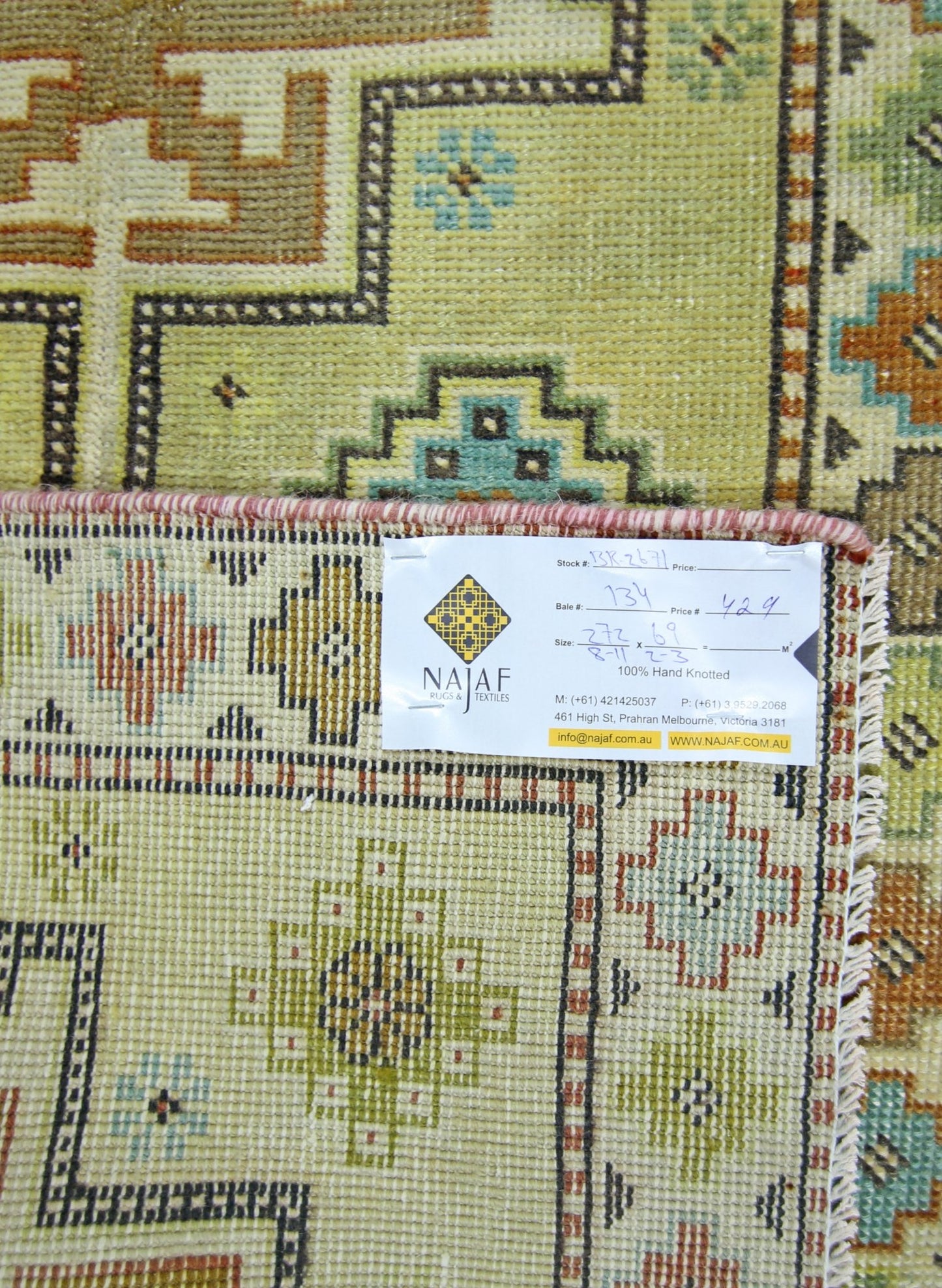 A vintage Persian runner featuring geometric patterns in shades of green, brown, and blue.