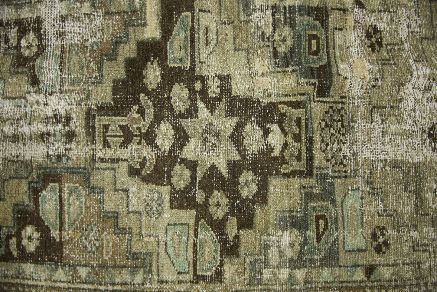 A vintage Persian runner featuring a distressed geometric pattern in shades of brown and sage.