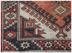 A vintage handwoven Persian runner featuring geometric patterns in red, blue, and cream wool.