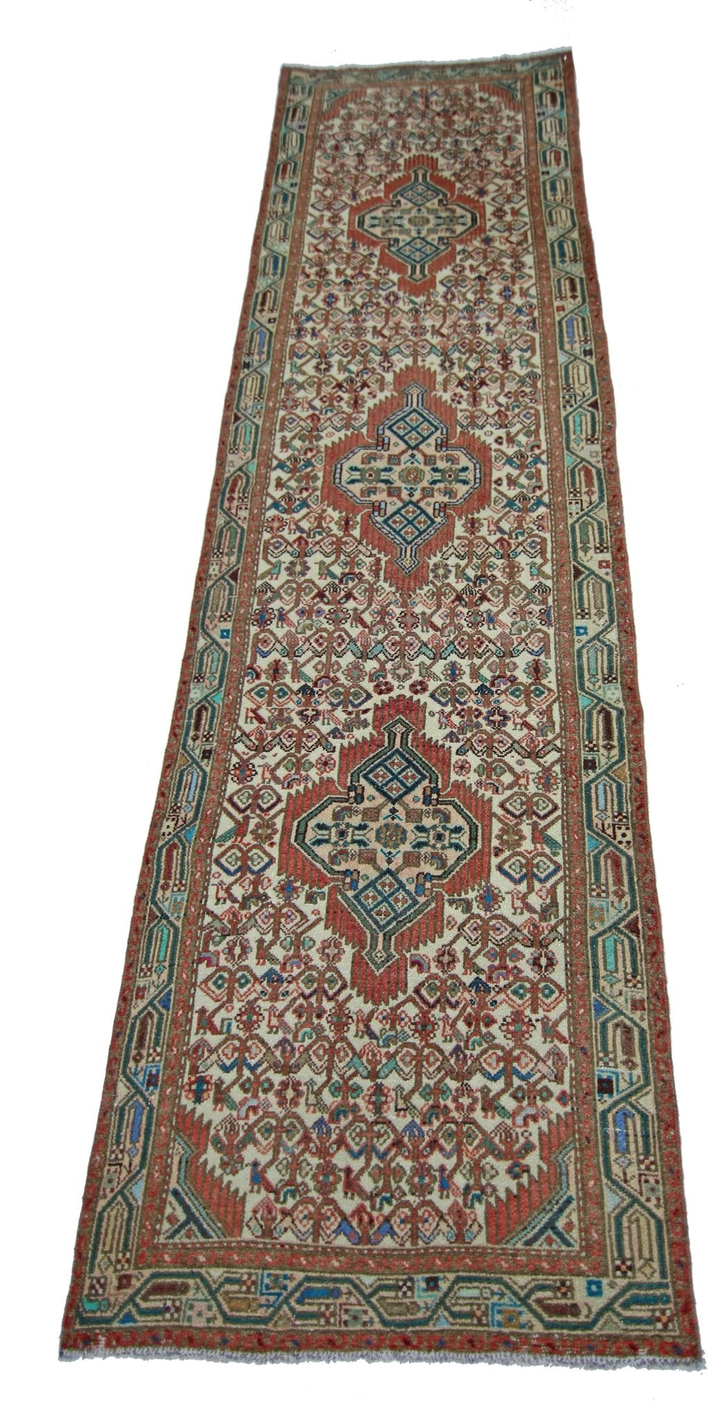 A vintage handmade Persian runner featuring a geometric pattern in red, blue, and cream tones.