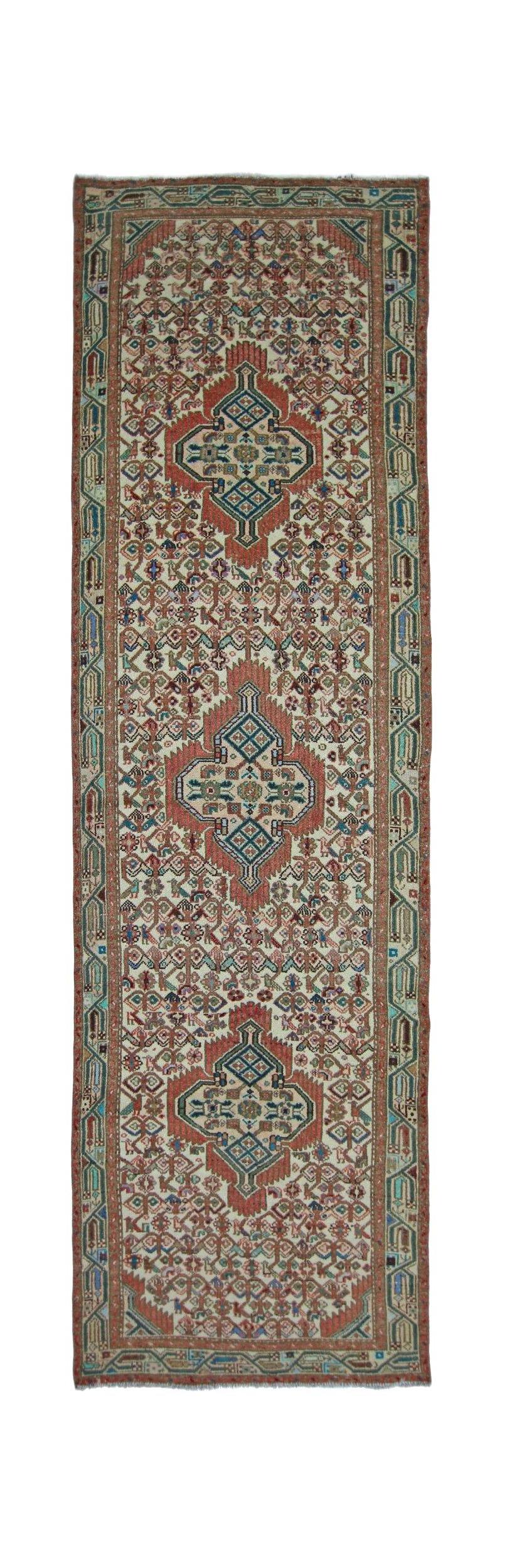 A vintage handmade Persian runner featuring three central medallions on a cream field.