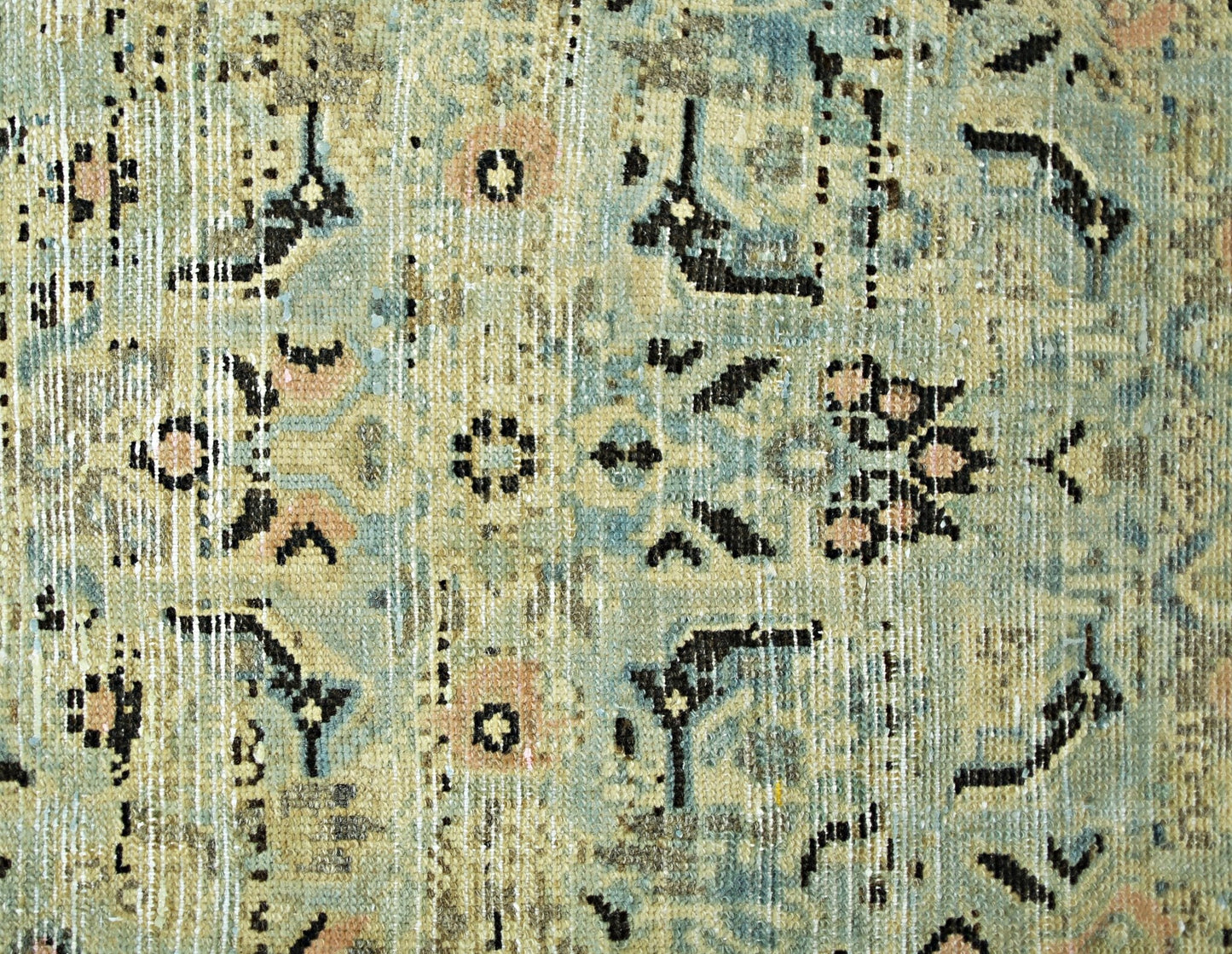 A vintage Persian runner featuring a distressed floral pattern in shades of blue and beige.
