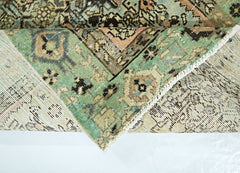 A corner of a vintage Persian runner with a green, pink, and brown geometric pattern.