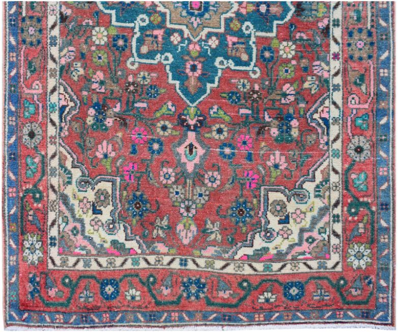 A handmade vintage Persian runner featuring a floral pattern in red, blue, and cream tones.