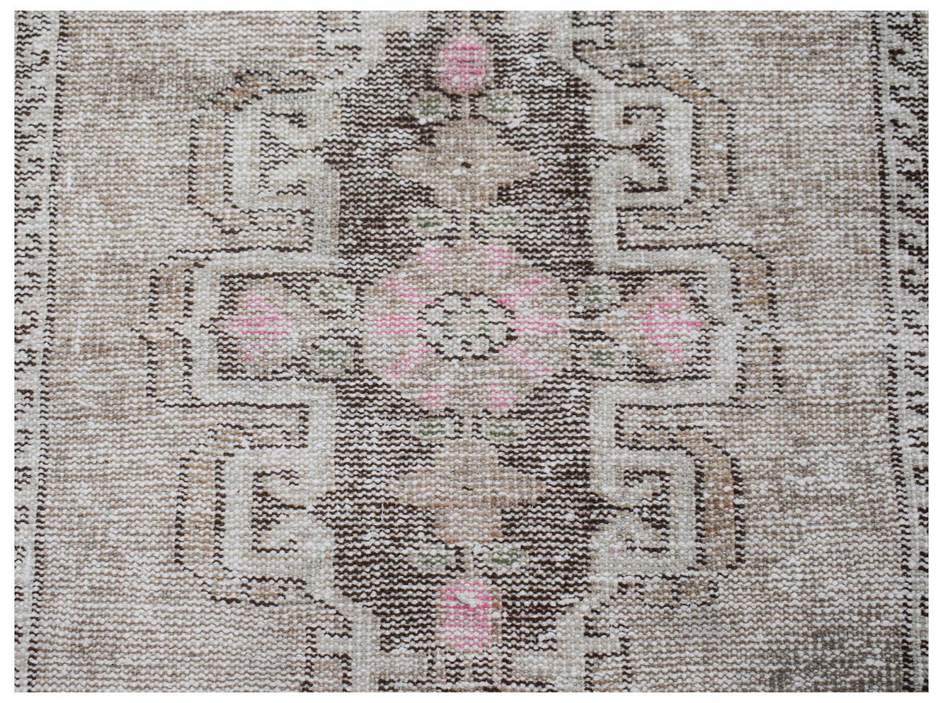 A vintage Persian runner featuring a central geometric medallion in brown, beige, and pink tones.