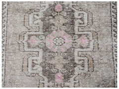 A vintage Persian runner featuring a central geometric medallion in brown, beige, and pink tones.