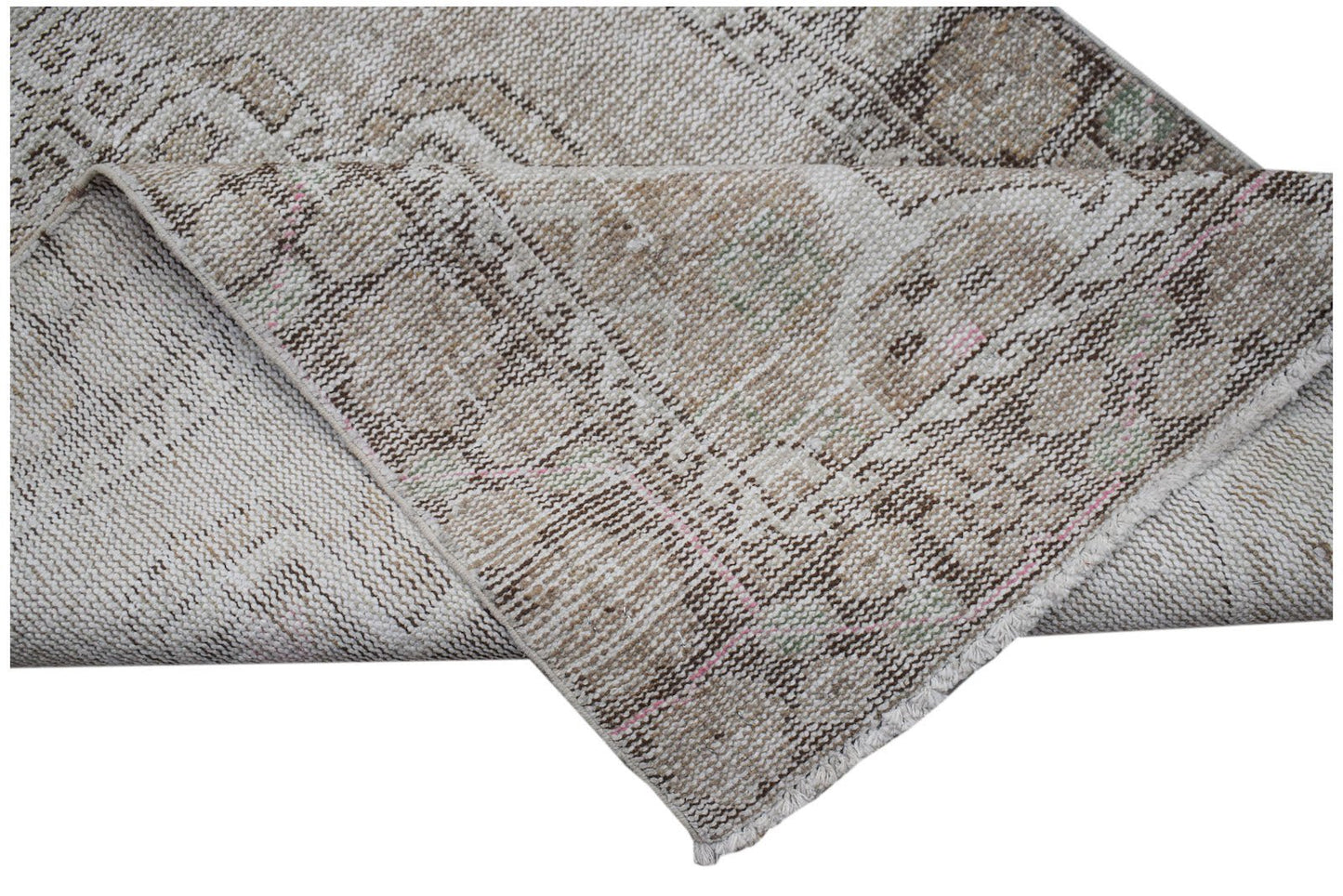A vintage Persian runner with a faded geometric pattern in neutral brown and beige tones.