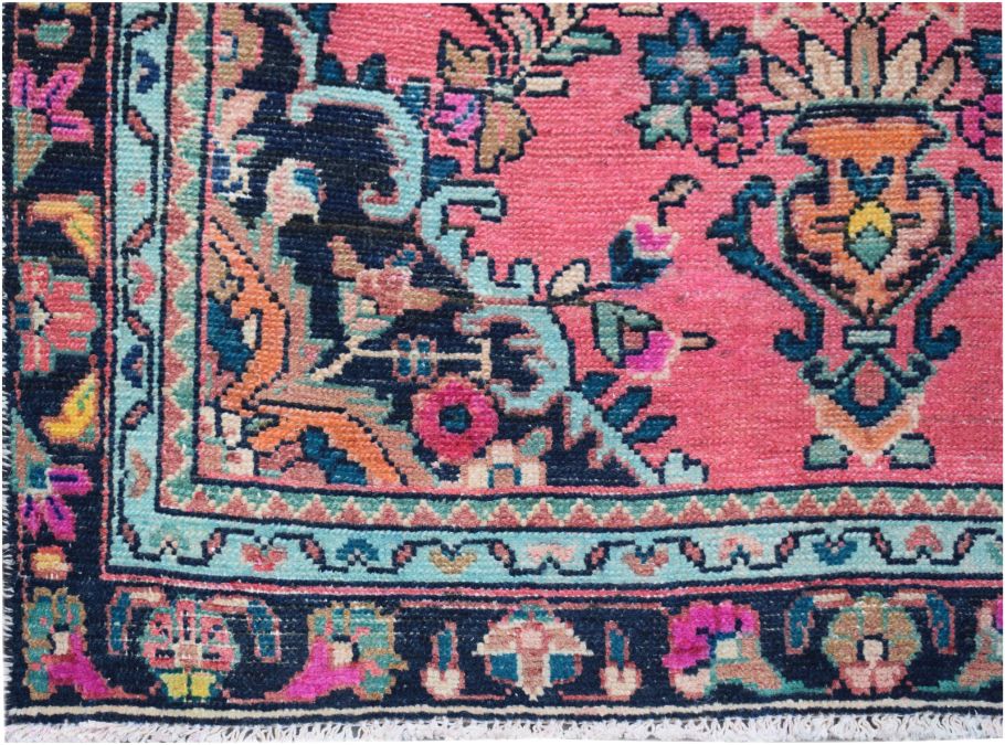 A vintage Persian runner featuring a vibrant pink field with intricate floral patterns and a dark border.