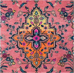 A vintage Persian runner featuring a central geometric medallion in yellow and orange on a pink field.