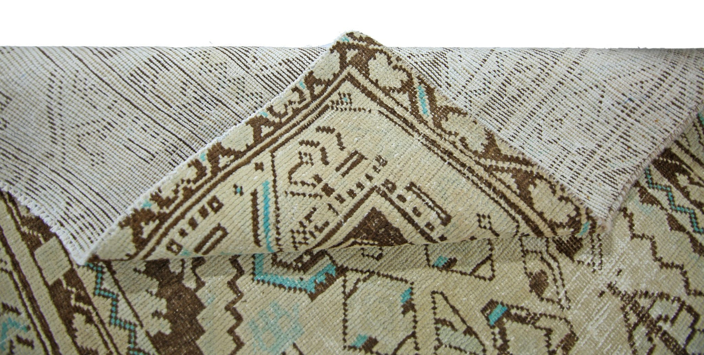 A corner of a vintage Persian runner is folded back to reveal its wool pile and cotton base.