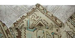 A corner of a vintage Persian runner is folded back to reveal its wool pile and cotton base.