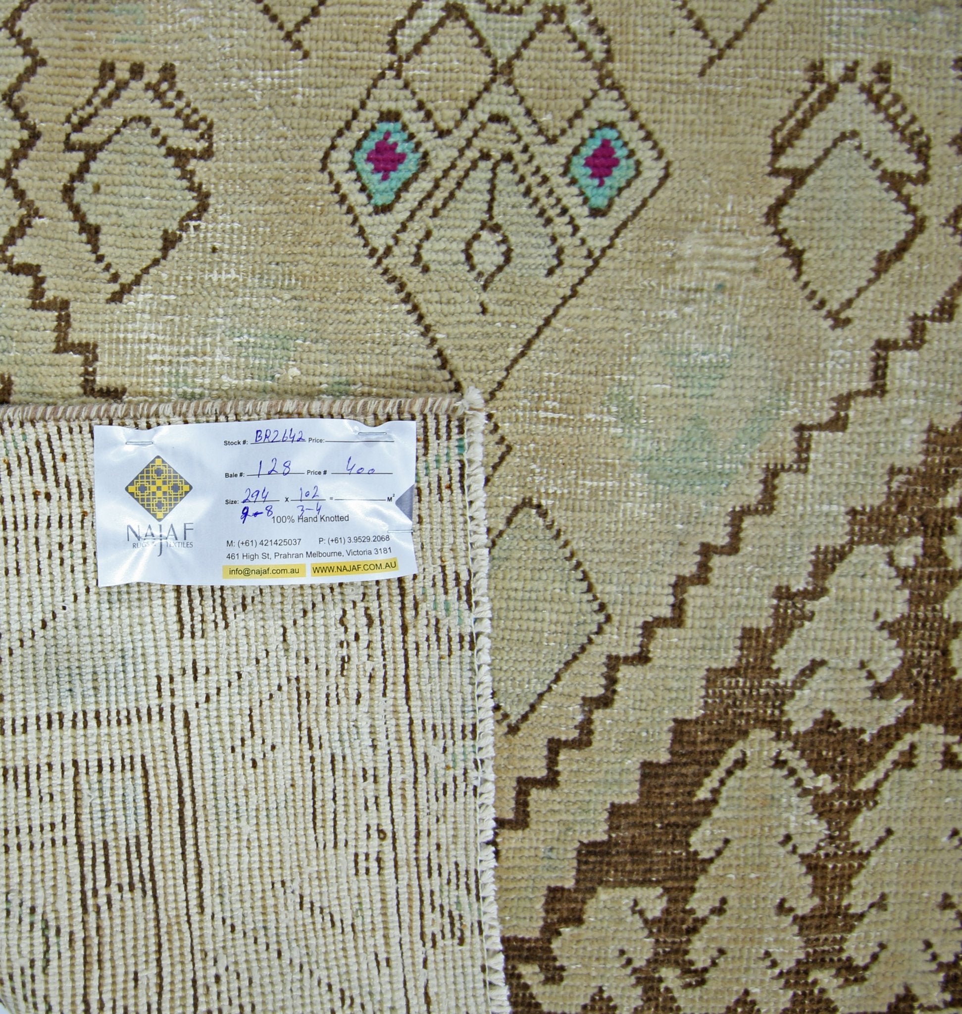 A vintage Persian runner featuring geometric diamond patterns in brown and cream tones.