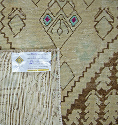 A vintage Persian runner featuring geometric diamond patterns in brown and cream tones.