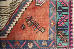 A vintage Persian runner featuring a geometric pattern in shades of red, blue, and teal.