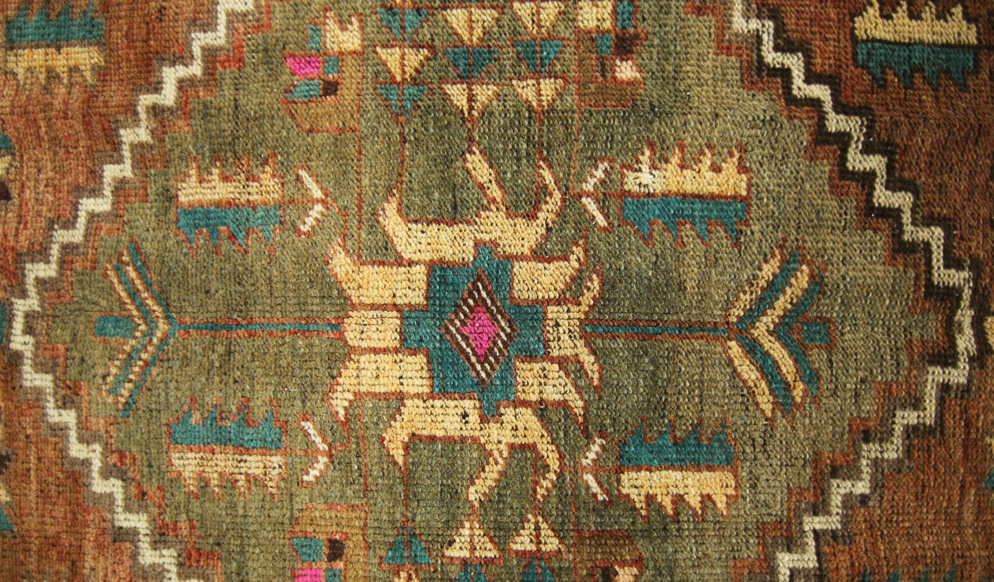 A vintage Persian runner featuring a central geometric medallion in olive, teal, and cream wool.
