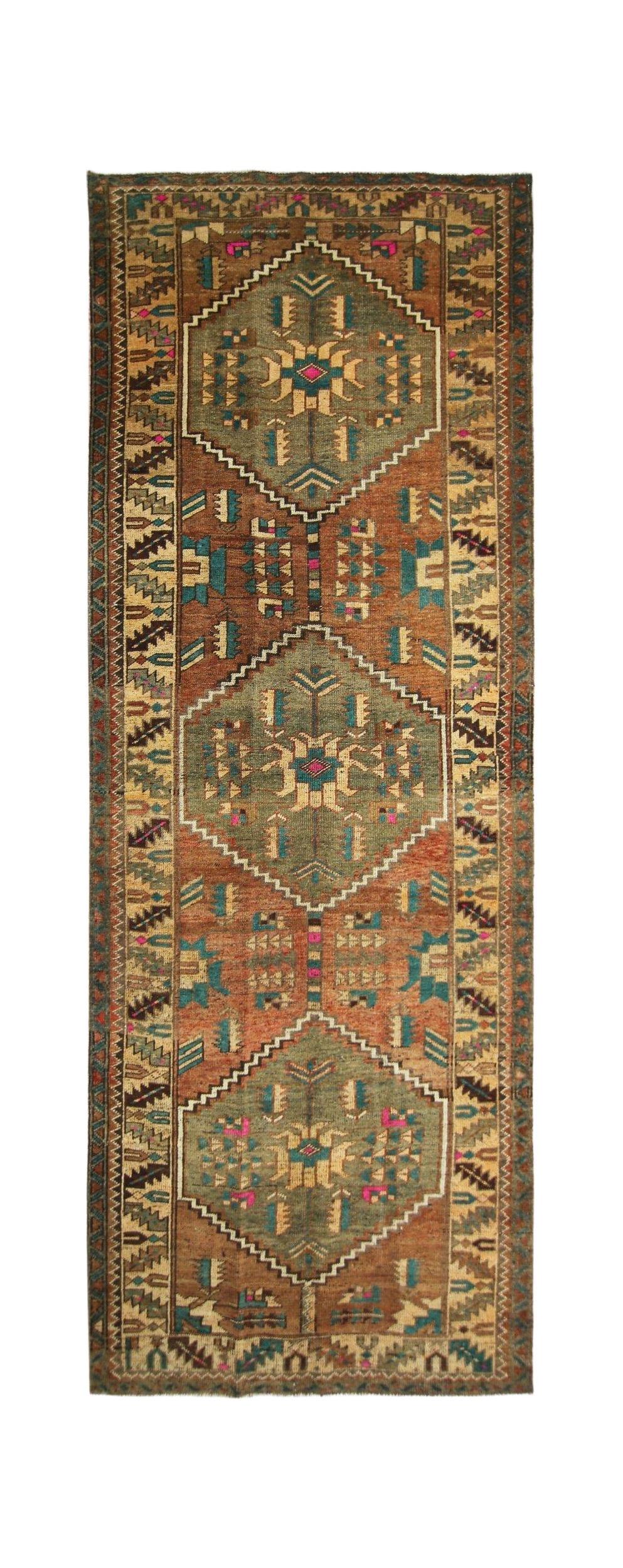 A vintage handmade Persian runner featuring three geometric medallions in earthy tones.