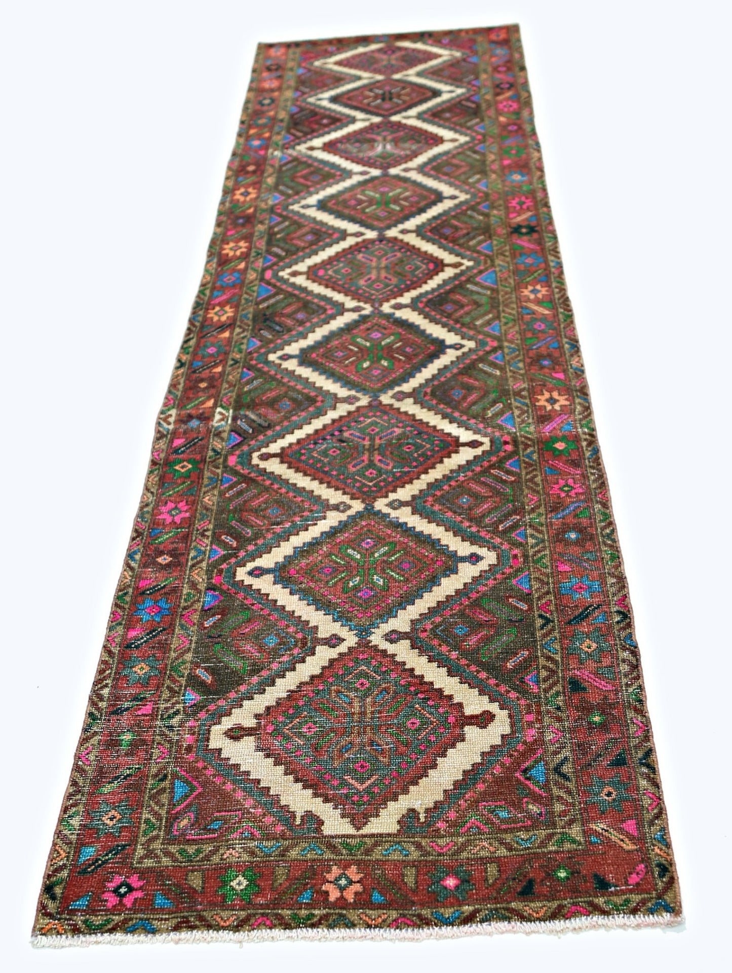 A vintage Persian runner rug featuring a series of diamond medallions in vibrant, colorful wool.