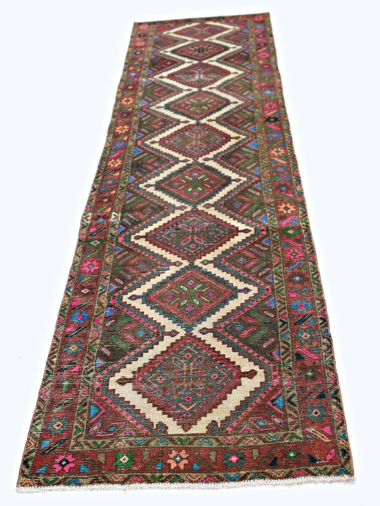 A vintage Persian runner rug featuring a series of diamond medallions in vibrant, colorful wool.
