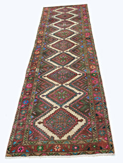 A vintage Persian runner rug featuring a series of diamond medallions in vibrant, colorful wool.