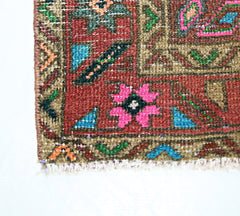 A close-up of a vintage Persian runner featuring a geometric floral pattern in vibrant colors.