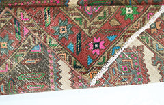 A vintage Persian runner featuring a vibrant, intricate floral pattern in wool on a cotton base.