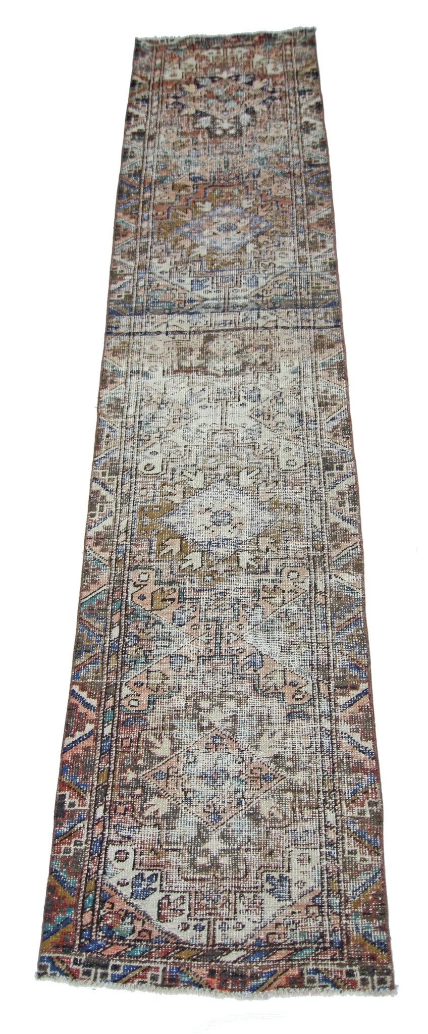 A handmade vintage Persian runner rug featuring a faded geometric pattern in muted earth tones.
