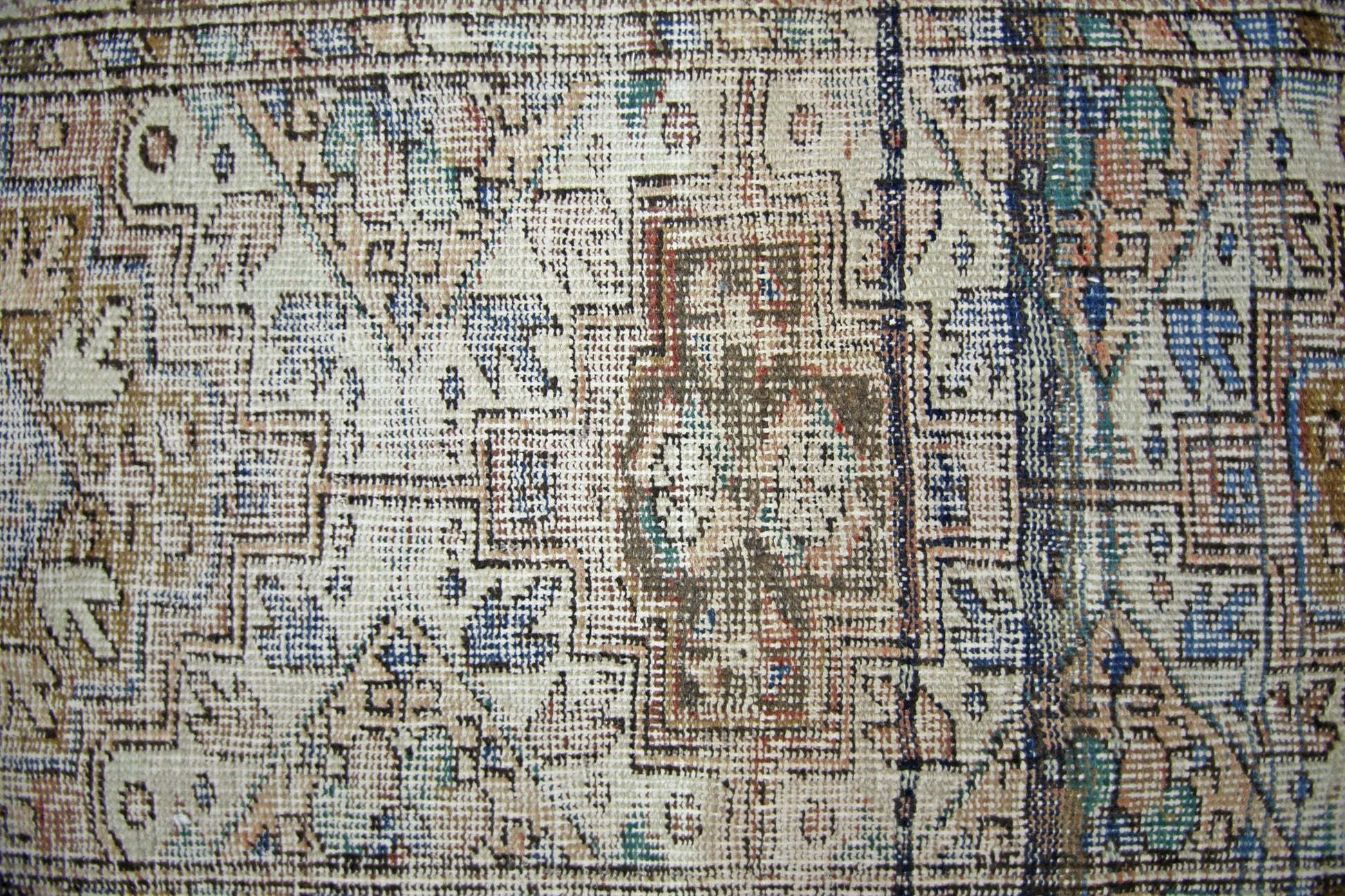 A vintage Persian runner featuring a geometric pattern in muted blue, brown, and cream tones.