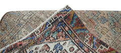 A corner of a vintage Persian runner showing intricate geometric patterns in wool on cotton.