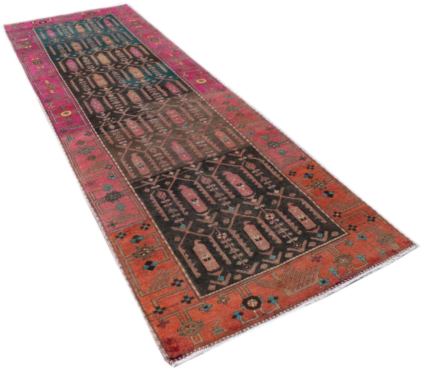 A handmade vintage Persian runner rug featuring a dark central field with geometric motifs and vibrant pink and orange borders.