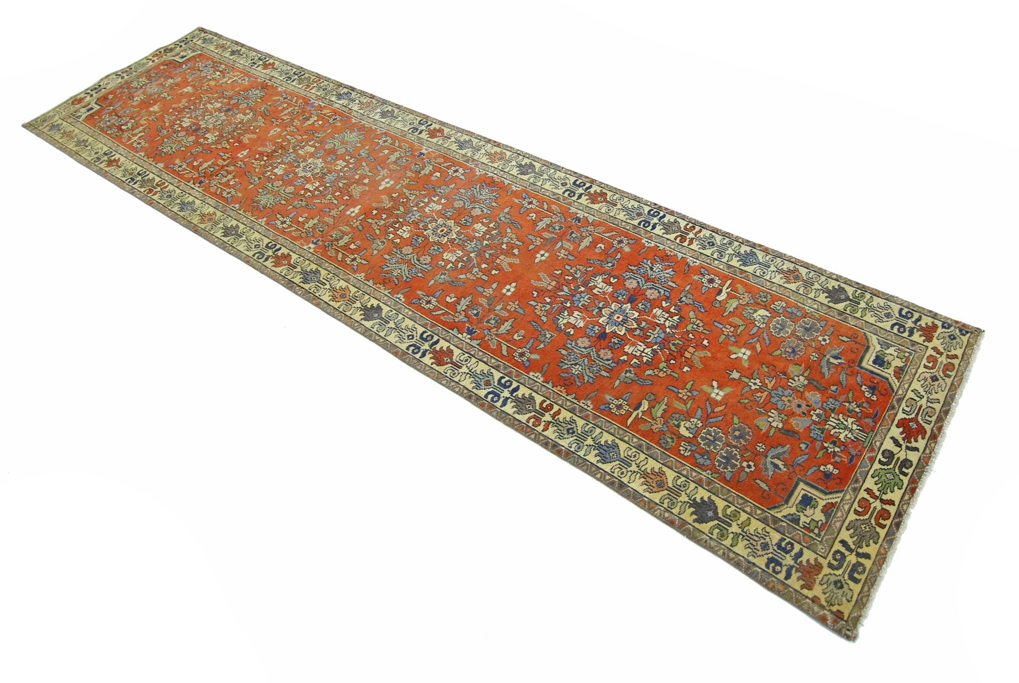 A vintage Persian runner featuring a floral pattern in shades of orange, blue, and cream.