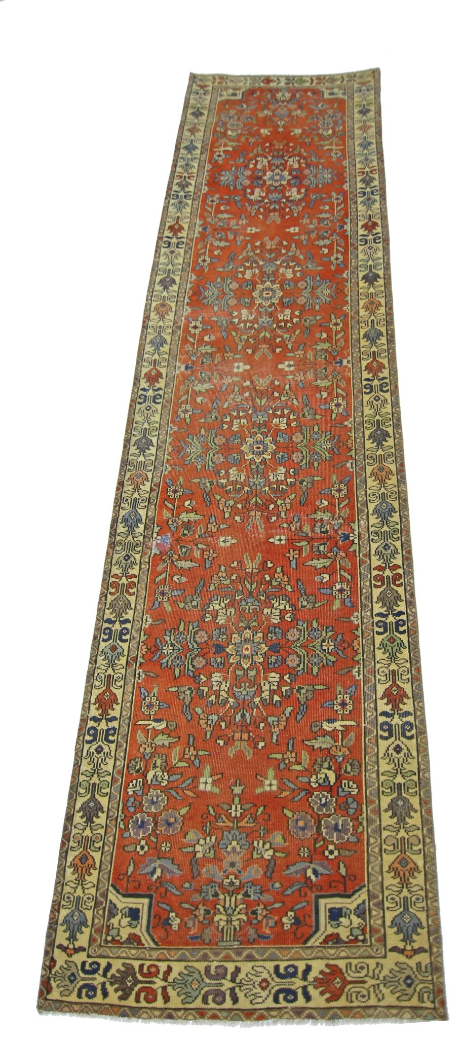 A vintage Persian runner featuring a floral pattern in shades of red, blue, and cream.