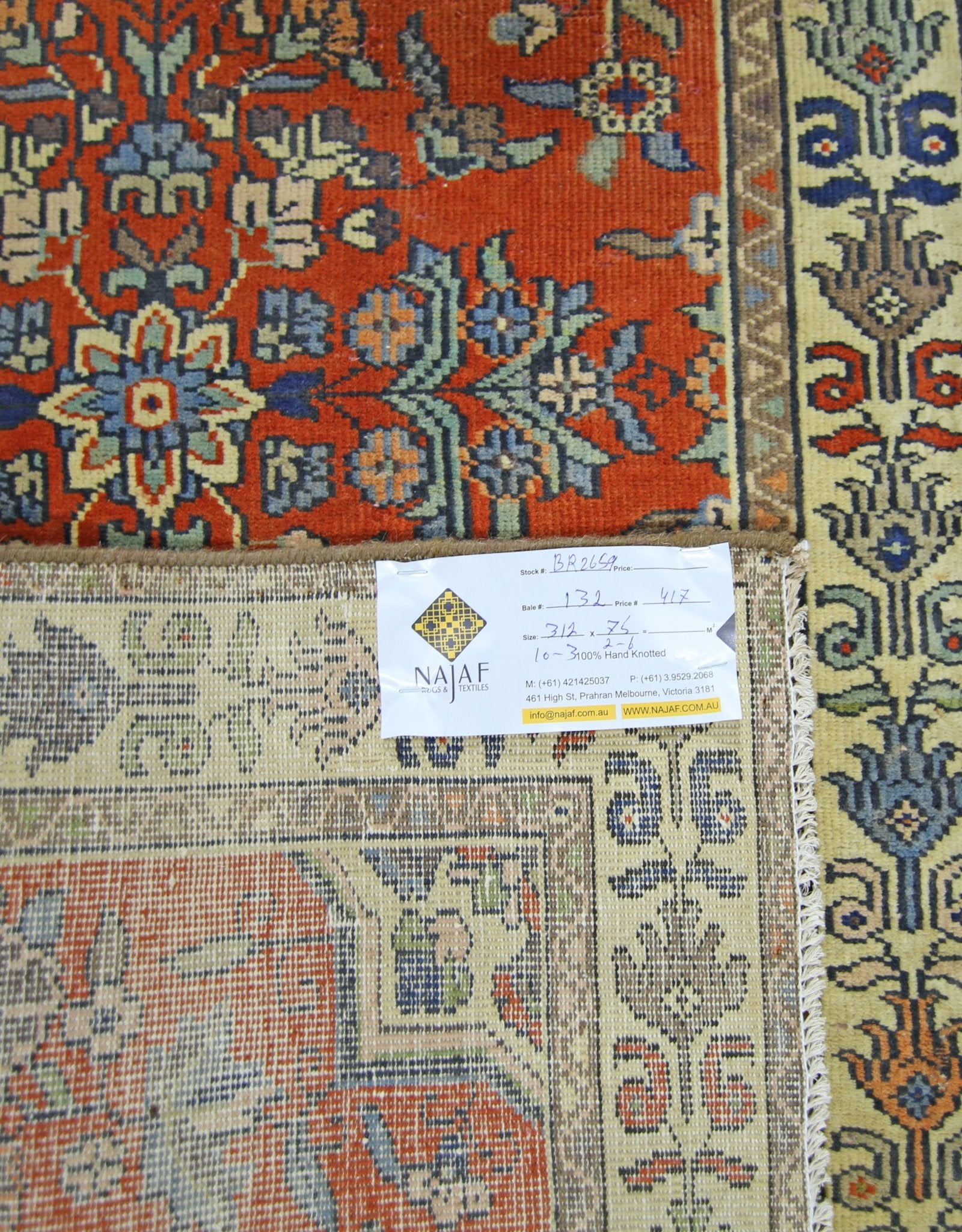 A vintage Persian runner featuring intricate floral patterns in red, blue, and cream tones.