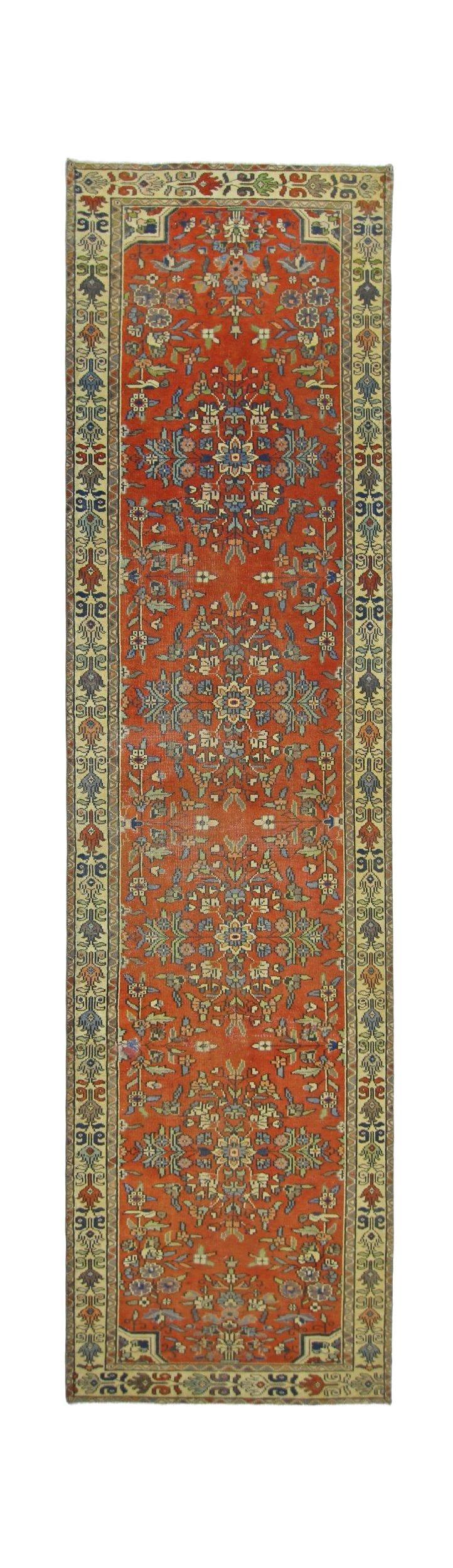 A vintage Persian runner rug featuring a floral pattern in shades of red, blue, and cream.