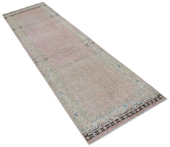 A vintage handwoven Persian runner rug featuring a faded pink and blue patterned design.