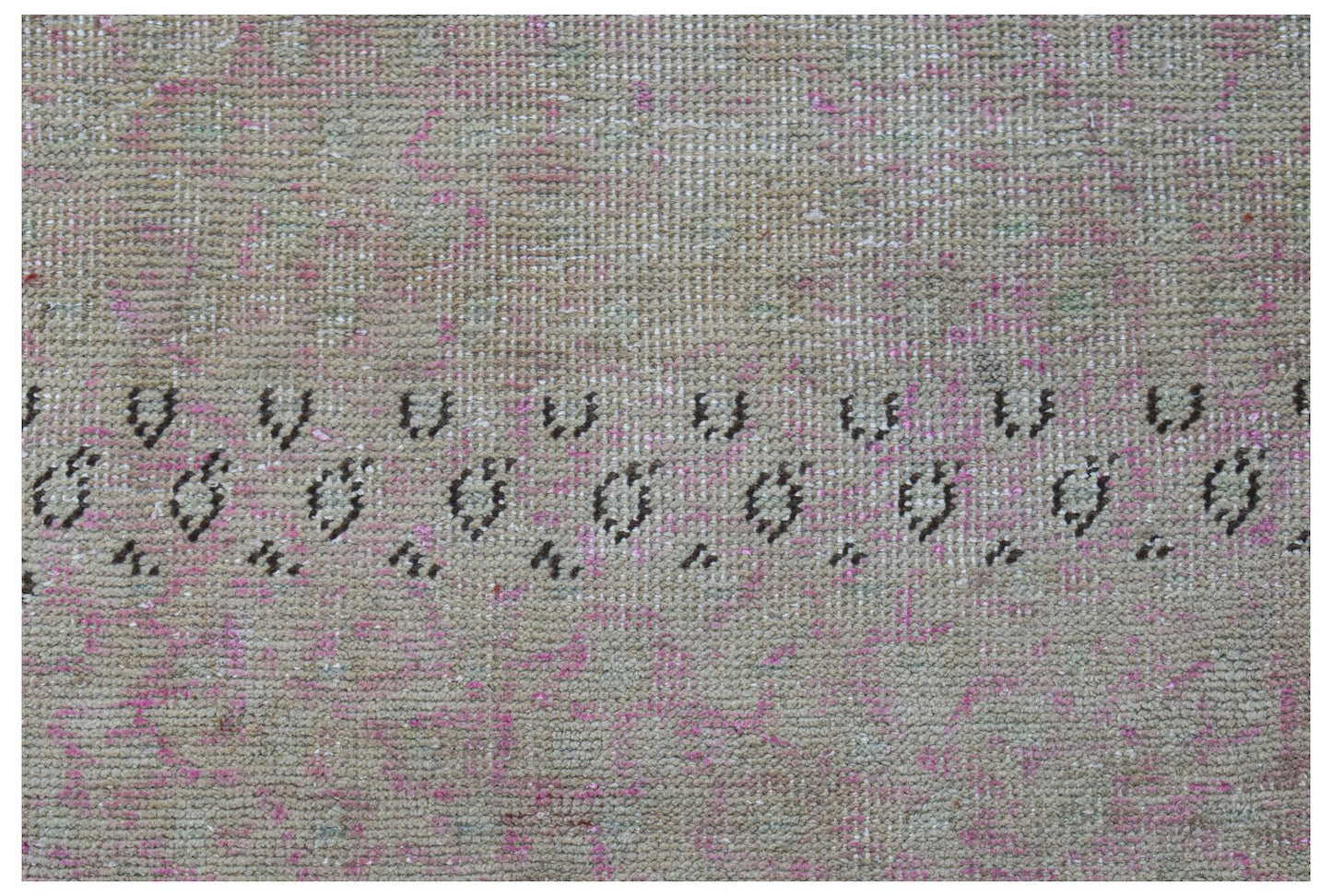 A vintage Persian runner featuring a faded beige and pink field with a dark geometric border.