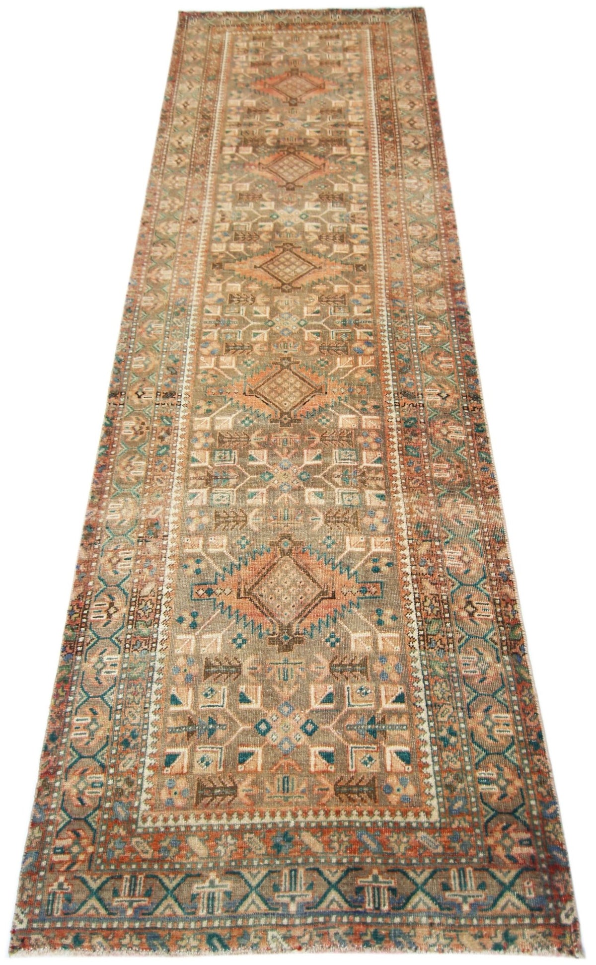 A vintage Persian runner rug featuring geometric patterns in muted earth tones and blue accents.