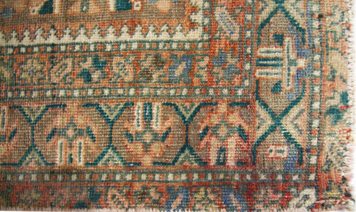 A close-up of a vintage Persian runner featuring intricate geometric patterns in wool.