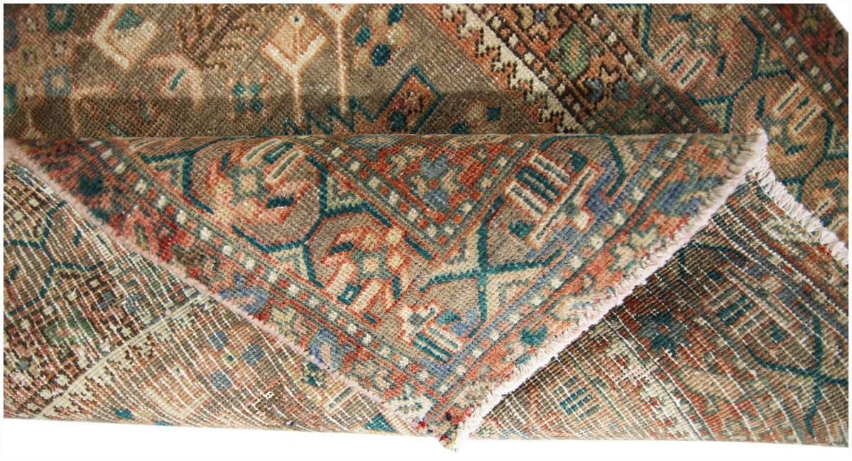A vintage Persian runner featuring intricate geometric patterns in muted earth tones and blue.