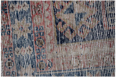A close-up of a vintage handwoven Persian runner featuring a geometric pattern in red and blue.