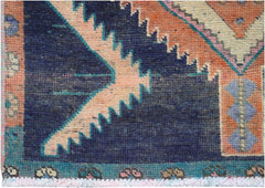 A vintage Persian runner featuring a geometric pattern in navy, orange, and cream wool.