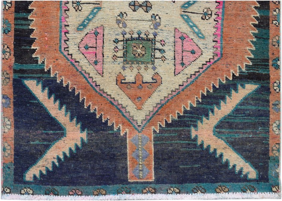 A handmade vintage Persian runner featuring a central geometric medallion on a dark blue field.