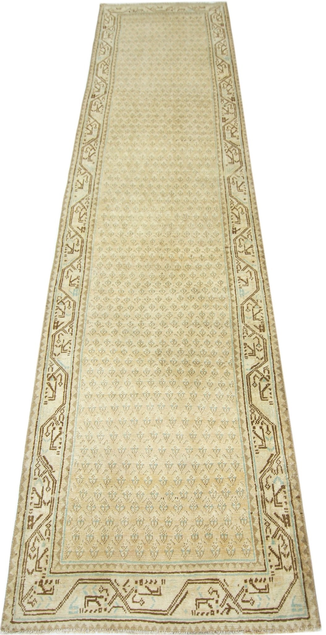 A vintage Persian runner featuring a repeating geometric pattern in beige and brown tones.