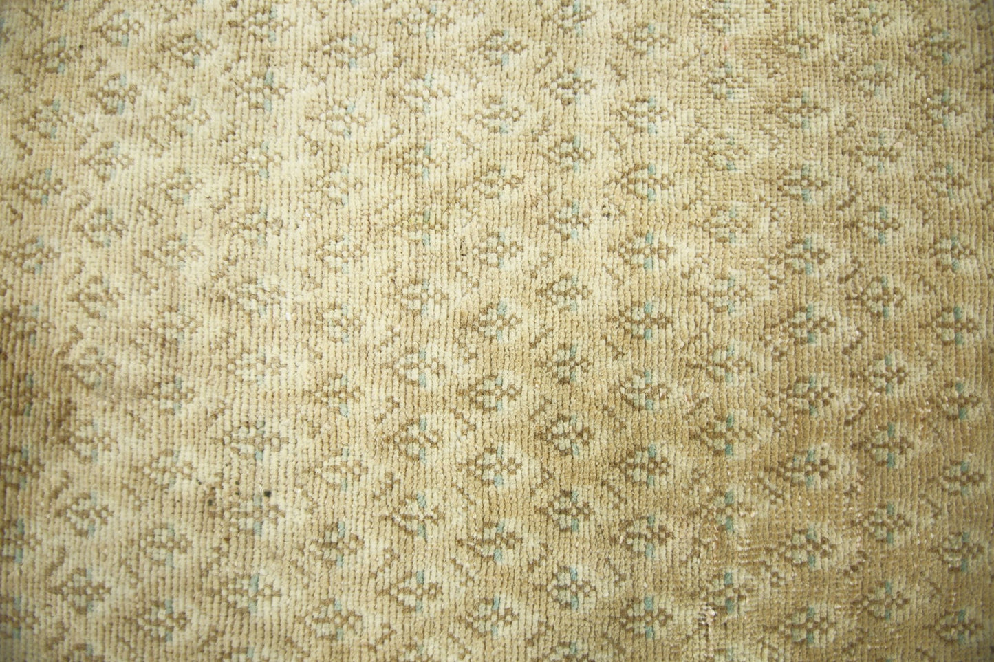 A vintage Persian runner featuring a repeating geometric pattern in muted tan and soft blue tones.
