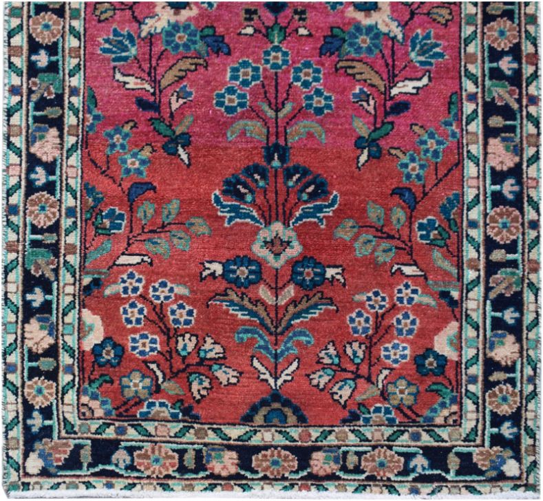 A vintage Persian runner featuring a floral pattern in shades of red, pink, and blue.