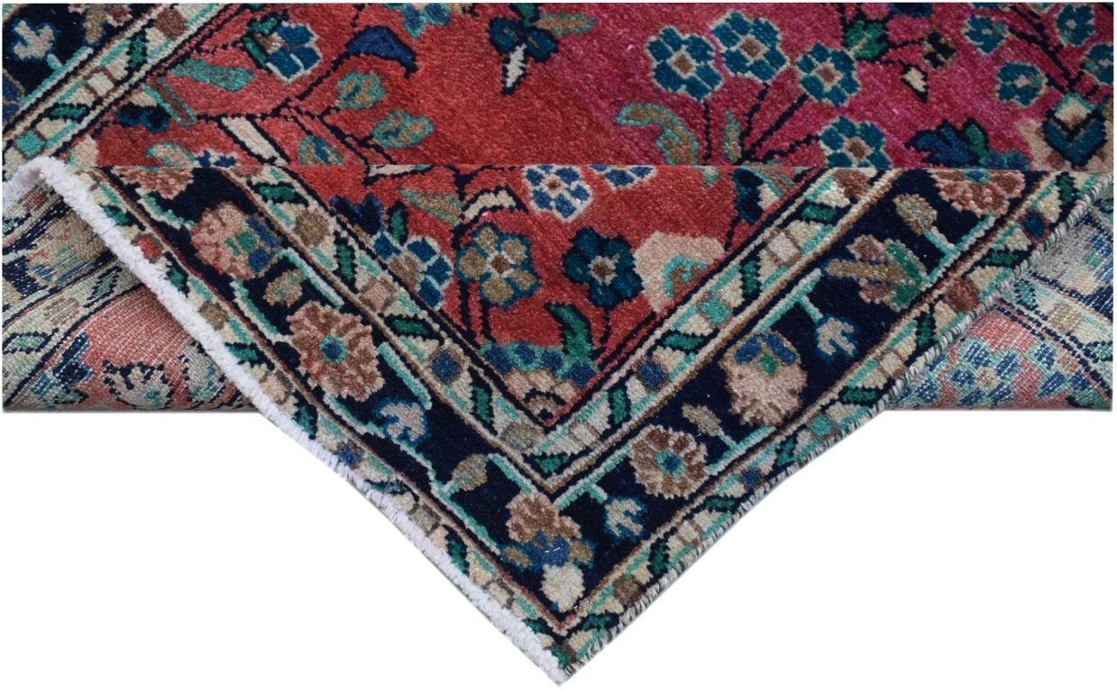 A vintage Persian runner with a red field, floral patterns, and a dark blue border.