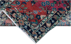 A vintage Persian runner with a red field, floral patterns, and a dark blue border.