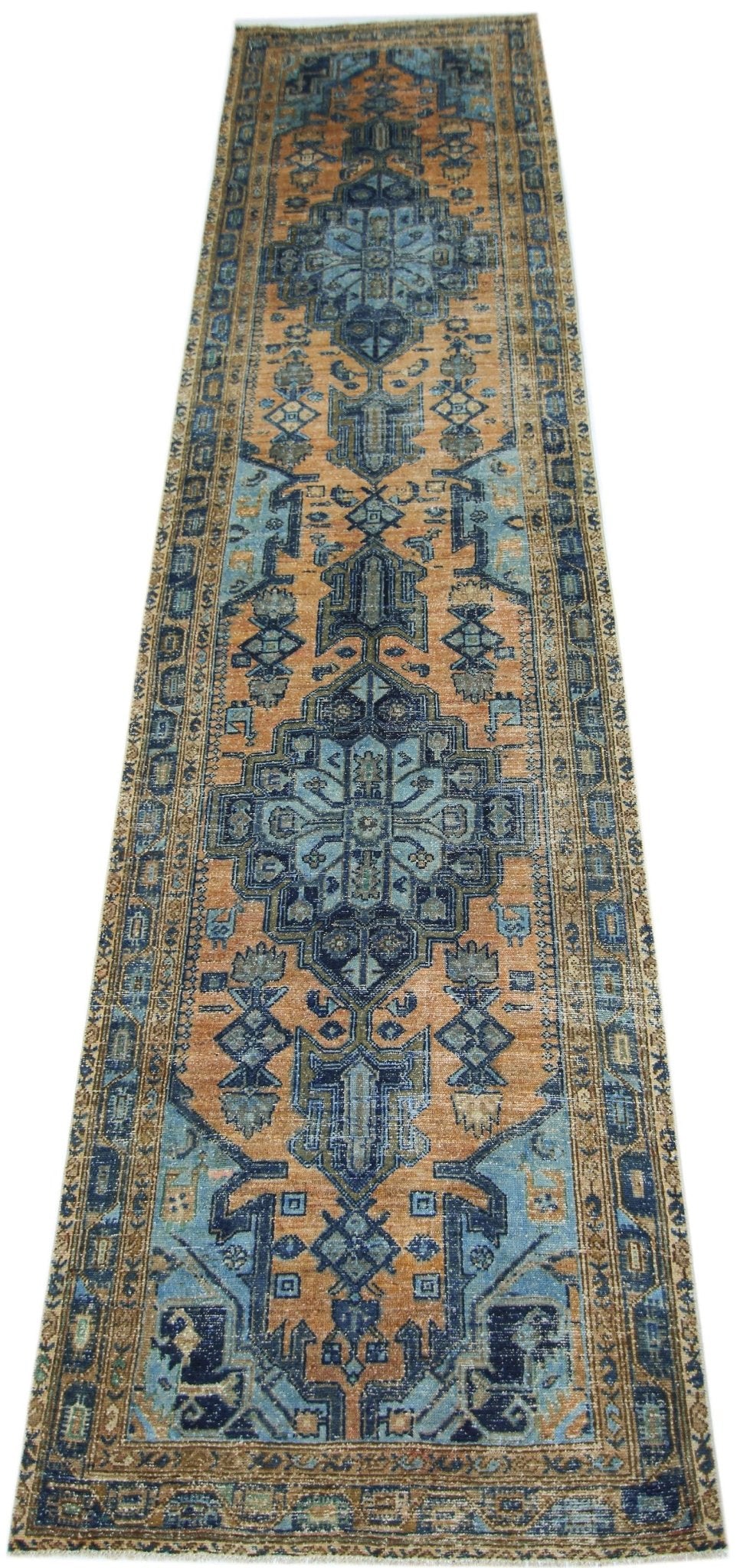 A vintage handmade Persian runner featuring a geometric floral pattern in blue and orange tones.